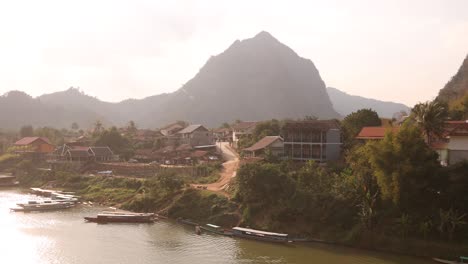 boats docked on a river village in the mountain town of nong khiaw in laos, southeast asia