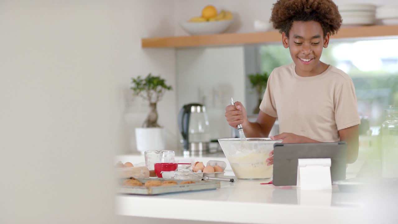 un niño afroamericano feliz horneando en la cocina, en cámara lenta