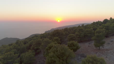 aerial view over zakynthos greek island woodland skyline towards hazy colourful sunset horizon