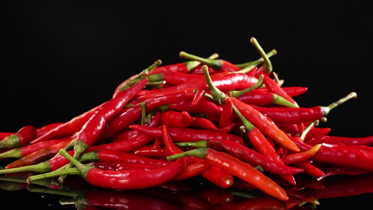 Chilies rotating on a reflective surface