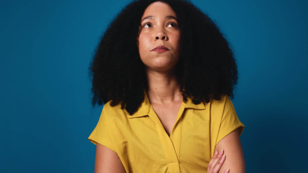 Portrait of a woman with curly hair against a blue background