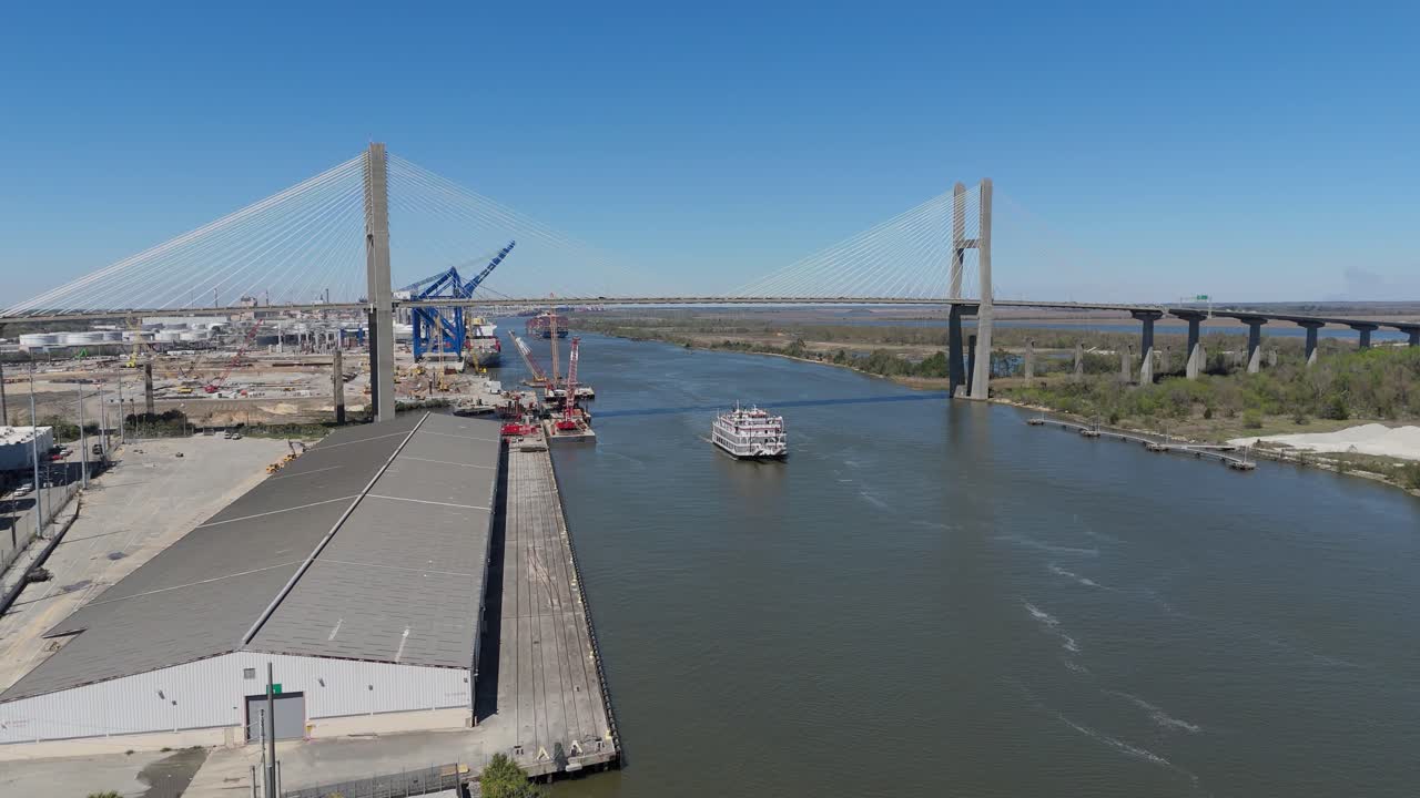 Aerial shot pushing in on The Georgia Queen Ferry cruising on The Savannah River with The Talmadge Memorial Bridge in the background.