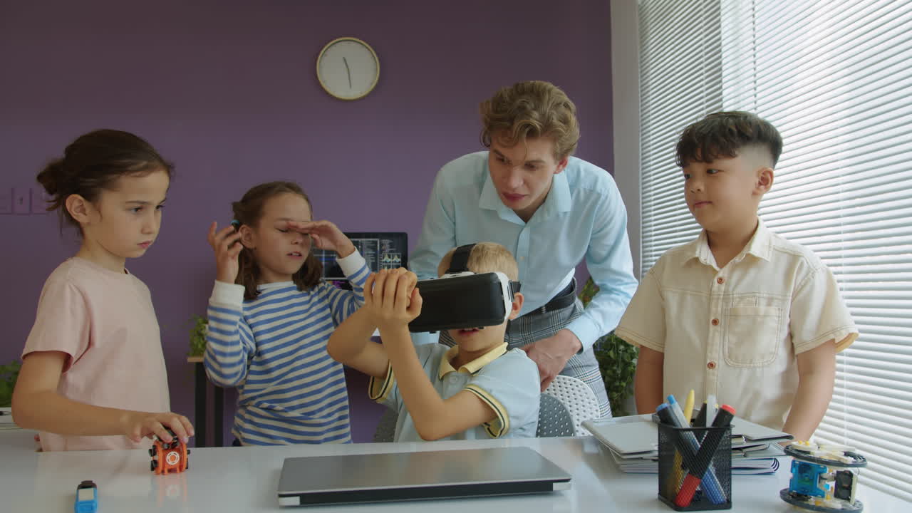Kids and Teacher Talking to Boy Using AR Headset at Developing Class