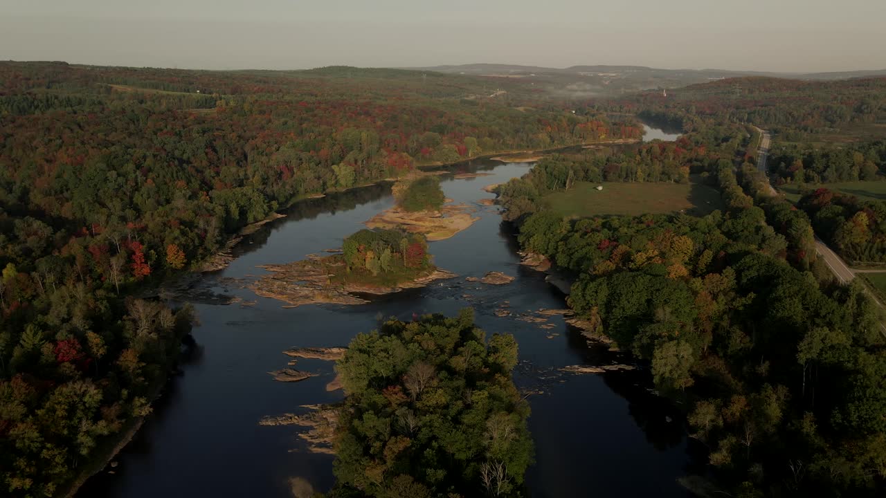 sobrevolando el abundante bosque con árboles otoñales en la temporada de otoño en el río saint-francois en windsor, quebec, canadá