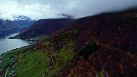 Aerial-of-Nordic-Norway-fjords-hills-and-forest-in-autumn-fall-near-lake