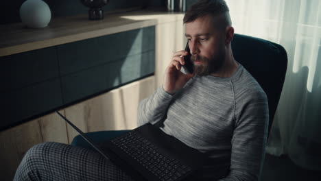 stock exchange trader in wireless headphones having call, monitoring real-time stocks, exchange market charts on multi-monitor desk setup. african american investment agent working. vertical shot.