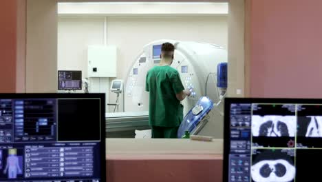 una sala de escaneo con computadoras y monitores al lado de la sala de escáner ct en un nuevo hospital moderno de tratamiento de cáncer.