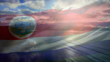 Digital-composition-of-waving-costa-rica-flag-against-aerial-view-of-the-beach