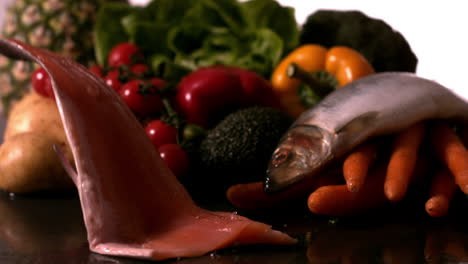 trout fillet falling in front of vegetable selection