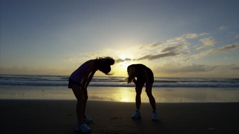 chicas asiáticas entrenando cardio en la playa al amanecer
