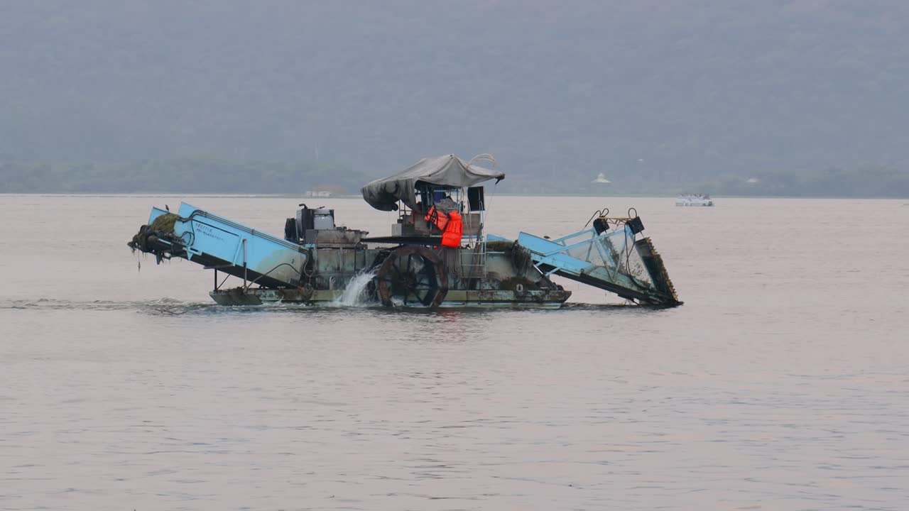 배는 물을 정화하고 물에서 쓰레기와 조류를 수집합니다. 호수 도시로도 알려진 우다푸르는 인도의 라자스탄 주에 있는 도시입니다.