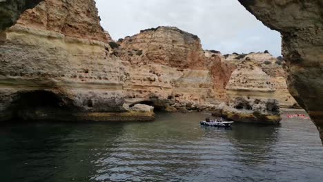 Drone-flying-backwards-through-sea-arch-on-Algarve-Coast