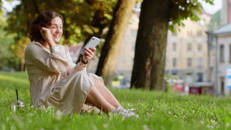 Young-woman-use-mobile-smartphone-celebrating-win-good-message-news-outdoors-in-urban-city-park