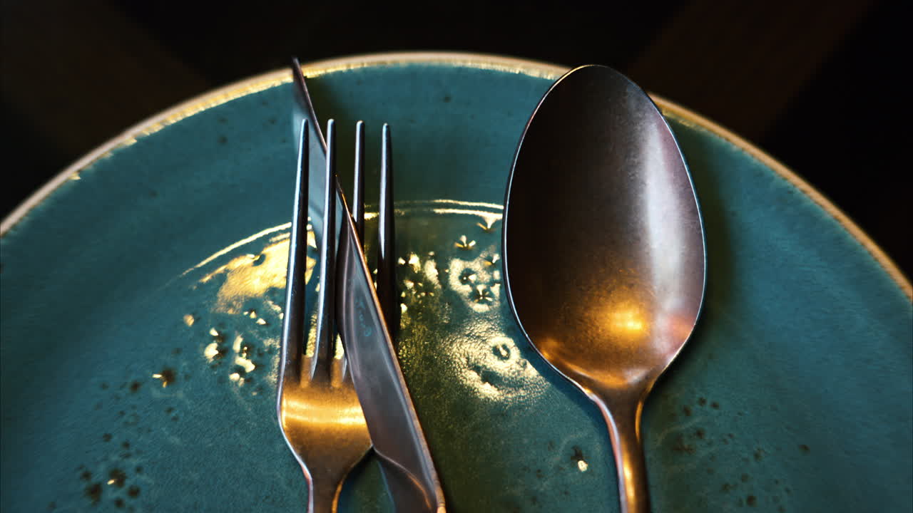 Stainless steel food cutlery on a ceramic plate