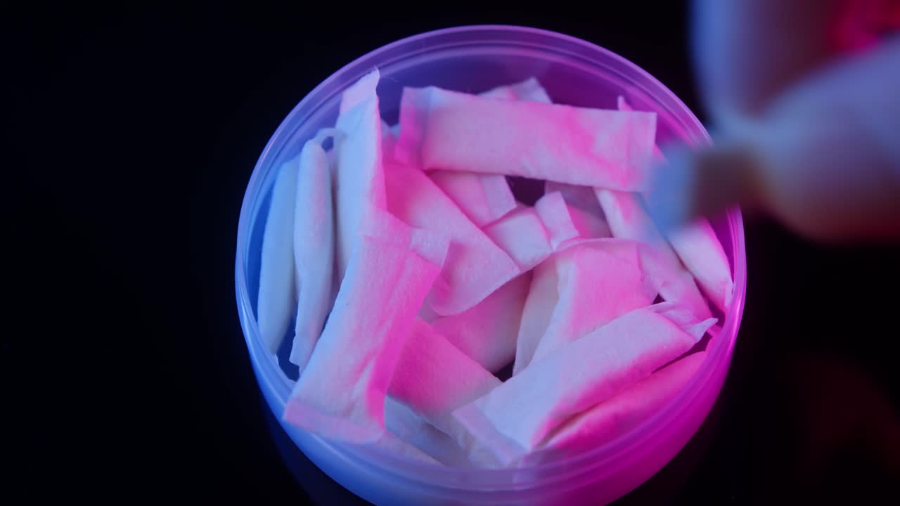 Snus nicotine tobacco close up, pack of tobacco for gum. unhealthy addiction. Man opening box with snus and taking one.