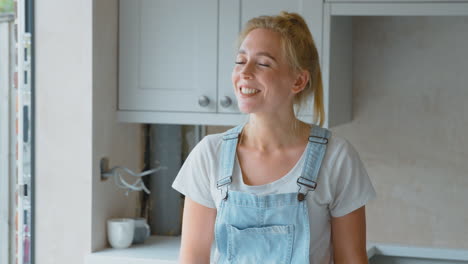 retrato de una mujer sonriente con trajes de baño renovando la cocina en casa