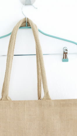 bolso y percha colgando en la pared blanca