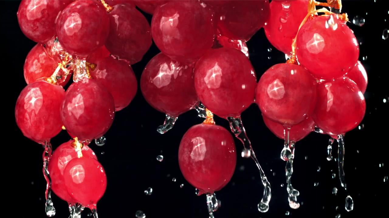 Uva rossa fresca con acqua che gocciola al rallentatore