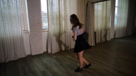 높은 프레임 속도의 10대 소녀가 어두운 스튜디오에서 춤을 추고 있습니다