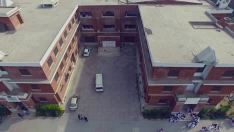 bombay, india, girls college aerial flight, a close up shot from top corridor of the college, traffic is going on the road
