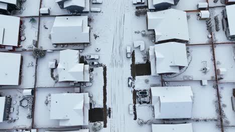 overhead aerial shot of empty streets in a neighborhood covered in snow