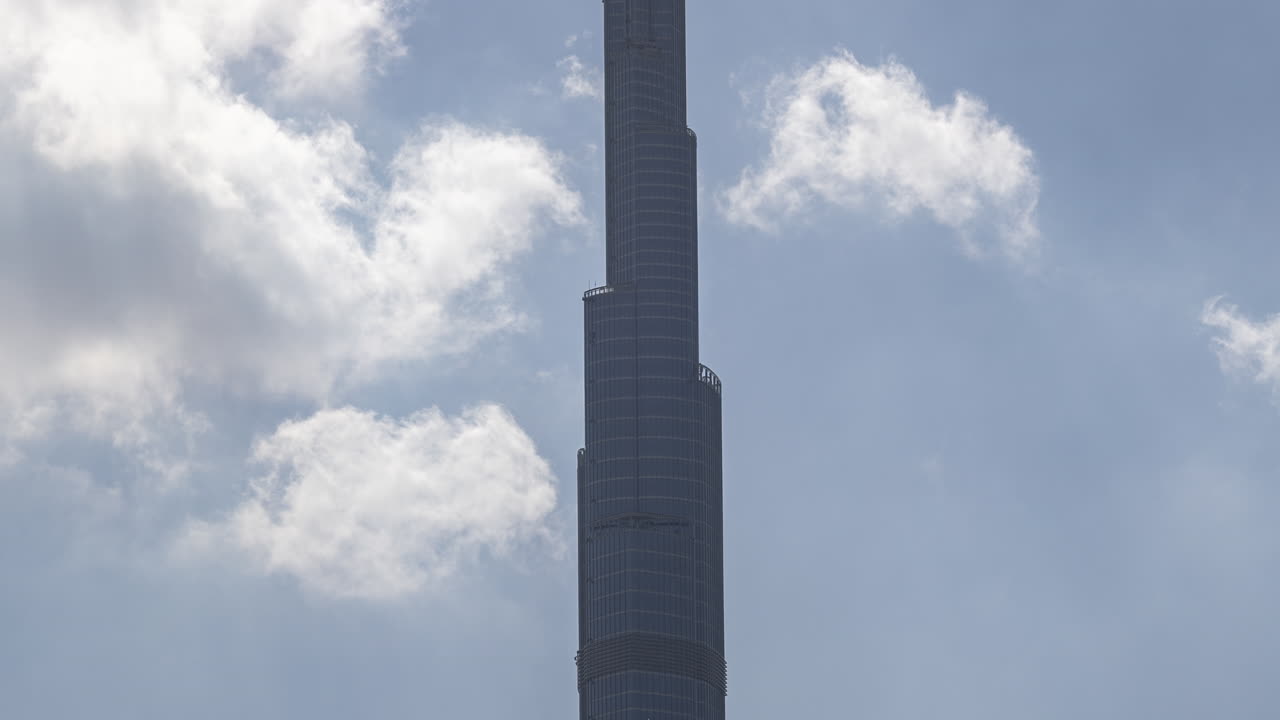 Tall Burj Khalifa Skyscraper Against Blue Sky with Moving Clouds