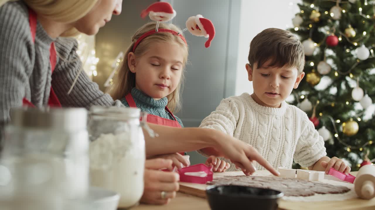 video de una familia cortando galletas de jengibre con un cortador de galletas