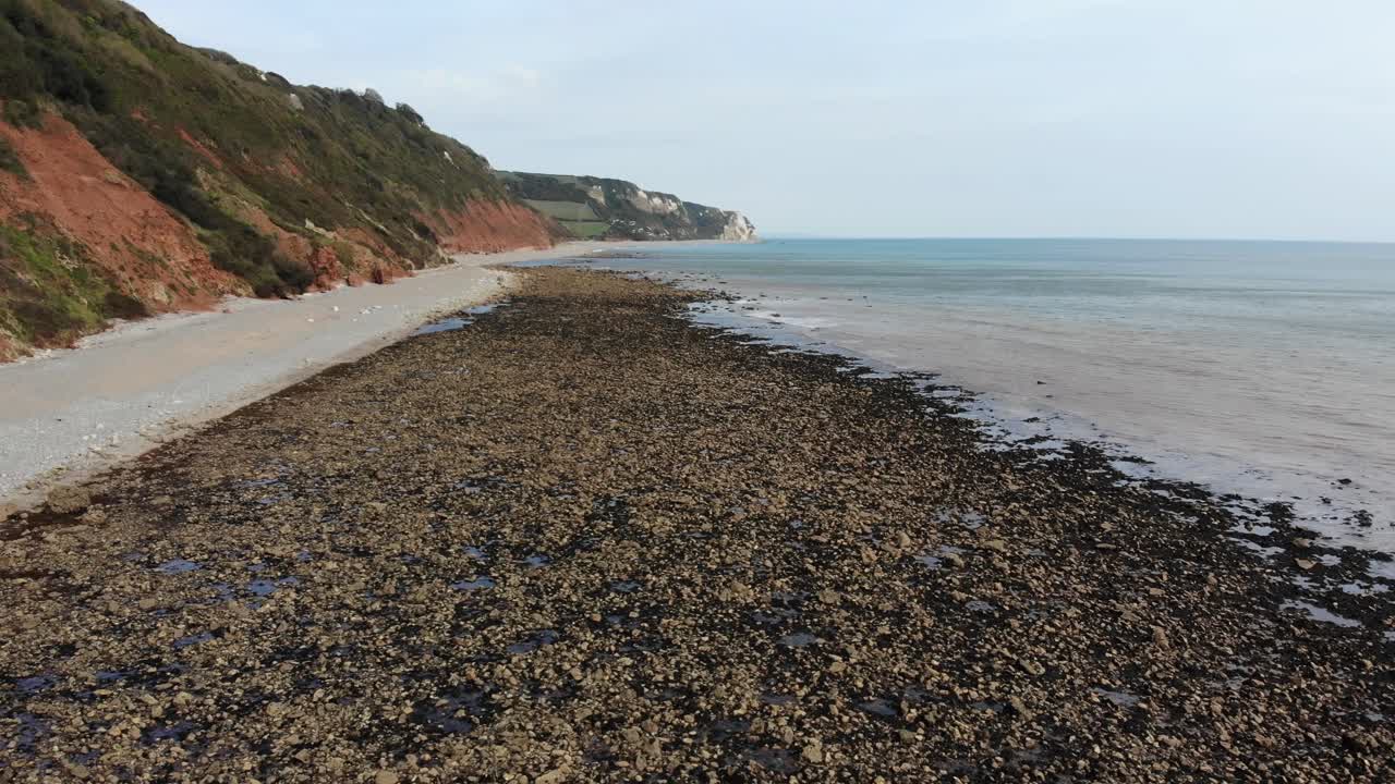 Aerial slow forward shot of the cliffs and beach at Branscombe England