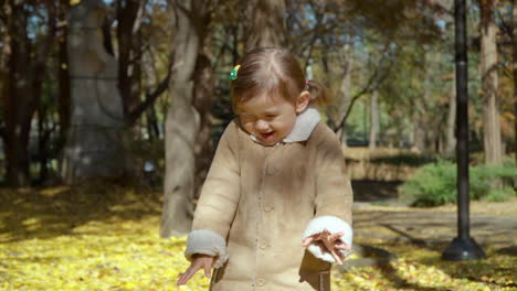 Yellow-Leaves-Falling-on-Toddler's-Head-in-an-Autumn-Park-in-Slow-motion