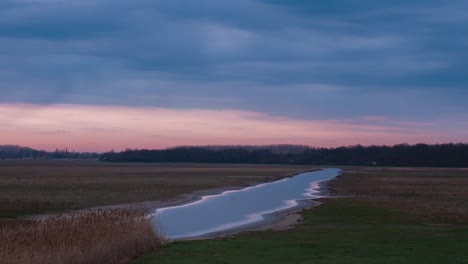 Zeitraffer-Eines-Sonnenuntergangs-Mit-Einem-Fluss-Im-Rahmen.4k