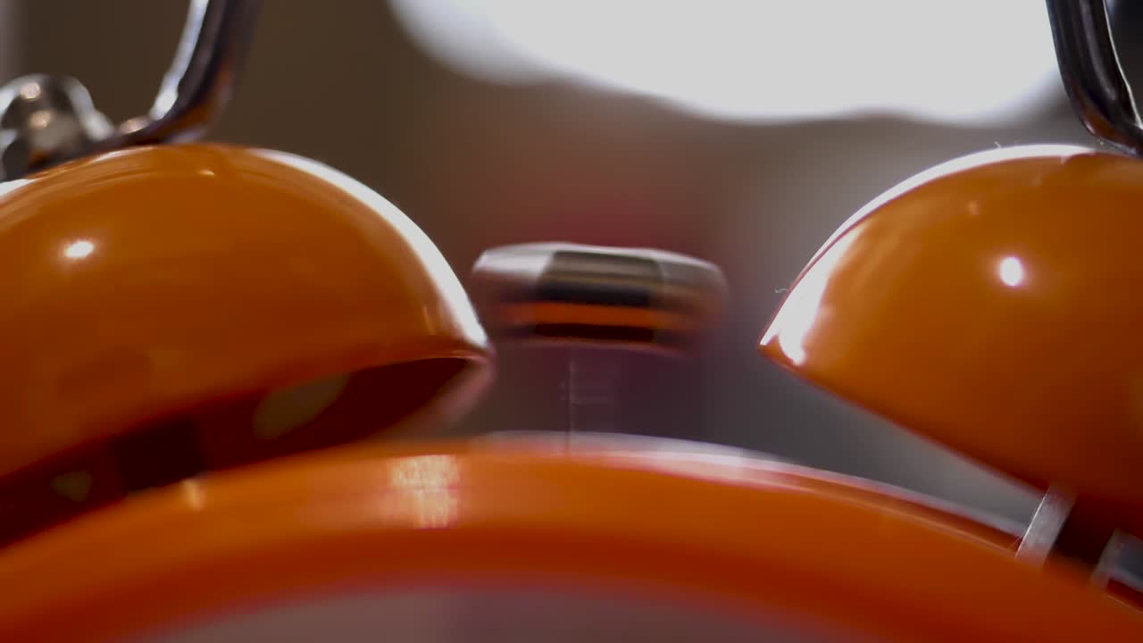 primer plano de un despertador de color naranja sonando