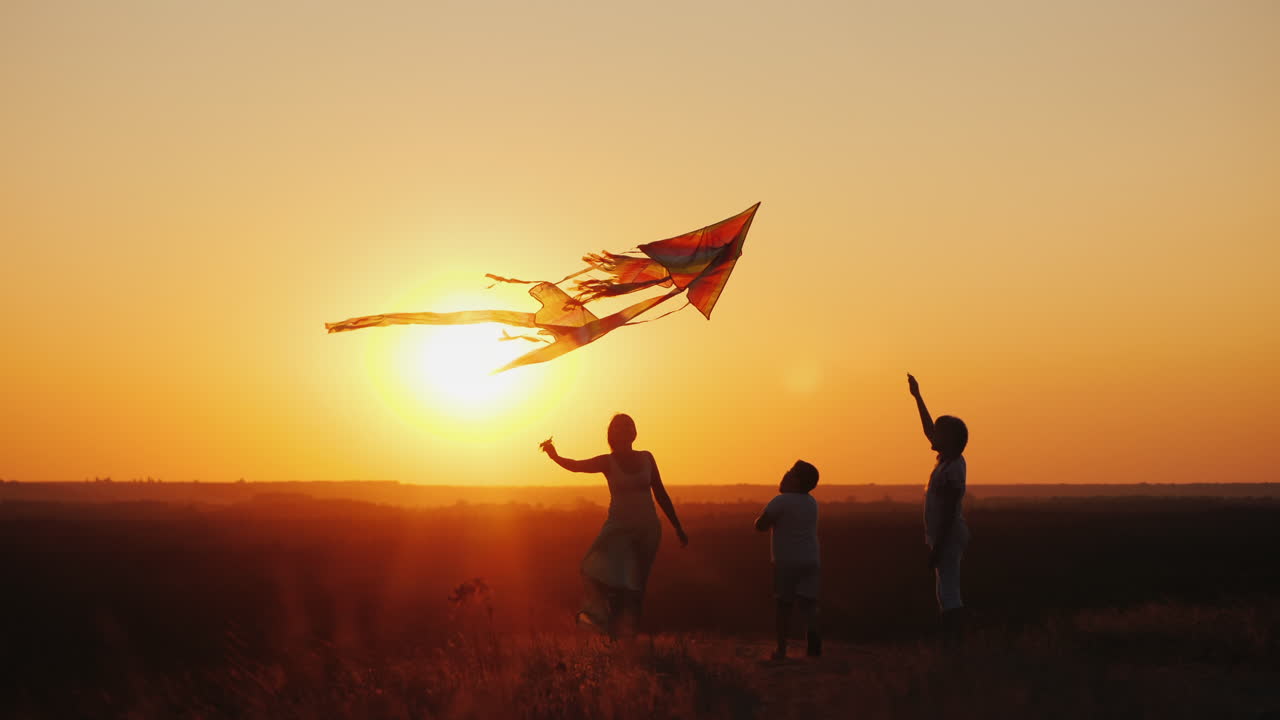 una mujer con dos hijos, una niña y un niño jugando cometas estilo de vida activo