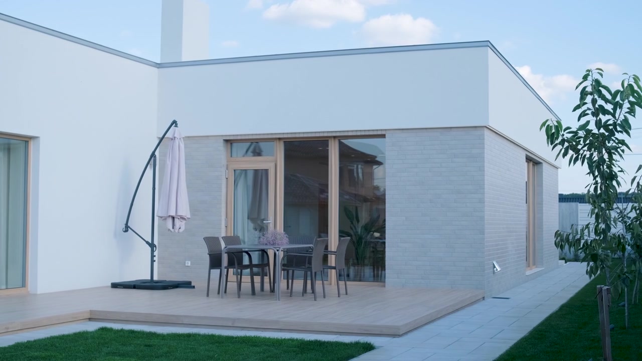 Esterno di una casa moderna con patio e mobili da pranzo