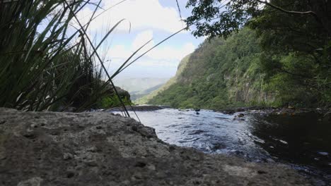 tranquil stream flowing through a rock carved creek leading to a spectacular valley view