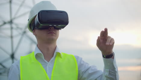 líneas eléctricas de alta tensión controladas por un ingeniero masculino que utiliza la realidad virtual para controlar la energía. fuentes de energía alternativas en una ciudad moderna