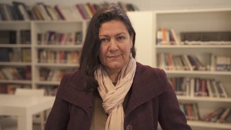 fashionable elderly woman smiling at camera inside library,close up slow motion