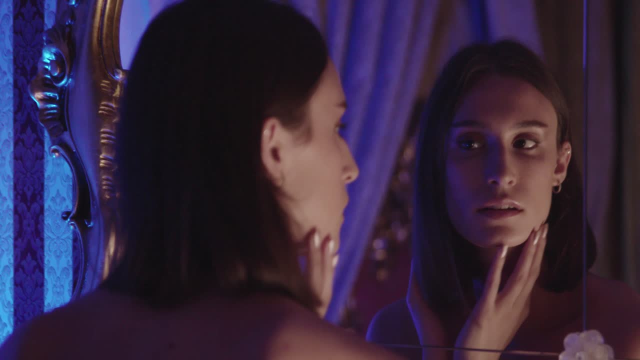 귀걸이를 입는 젊은 갈색 여성