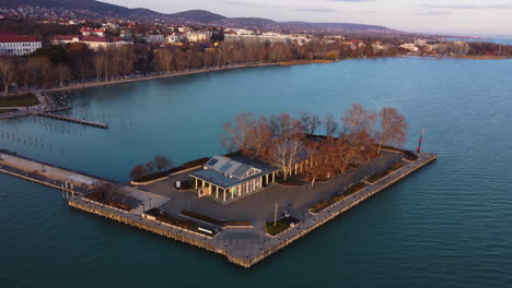 drone orbiting a small island near balatonfured with dock, boats and shoreline structures