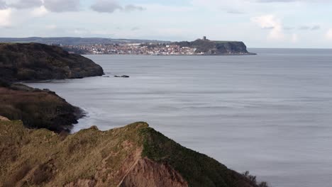 Imágenes-Aéreas-En-Movimiento-Lento-De-La-Costa-Norte-De-Yorkshire-Con-La-Ciudad-De-Scarborough-En-La-Distancia