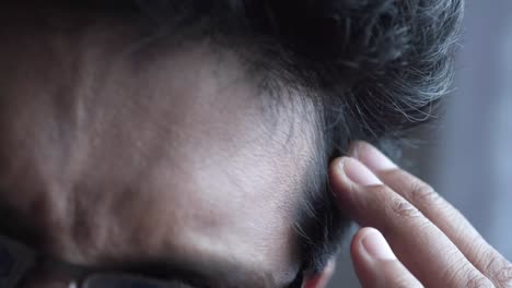 closeup of a man touching his forehead