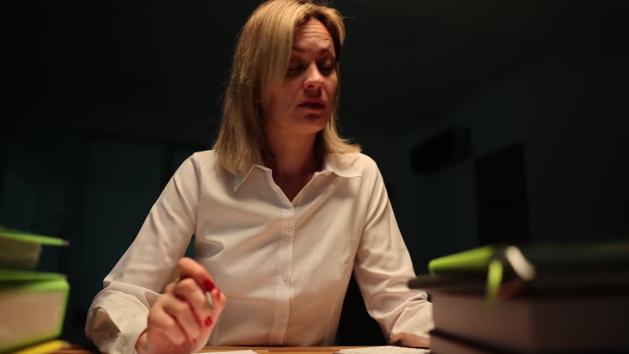 A woman experiences stress, headache, and fatigue while working late at her desk