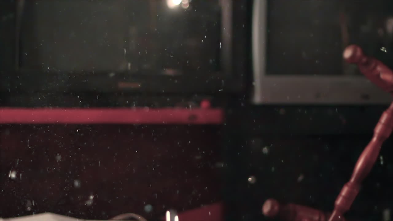 한 젊은이가 구슬이 들어 있는 유리 꽃병에 도끼를 휘두릅니다.