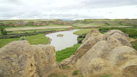 Escribiendo-En-Los-Parques-Provinciales-De-Piedra-Bandlands-Y-Hoodoos-Con-Río-En-Un-Desierto-En-Alberta,-Canadá-Durante-El-Día-Nublado