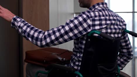 man in a wheelchair leaving office