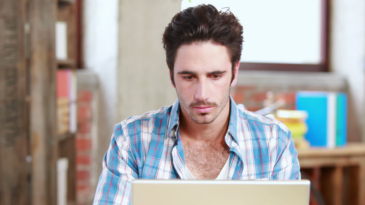 hombre de negocios casual usando su portátil en el escritorio