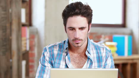 hombre de negocios casual usando su portátil en el escritorio