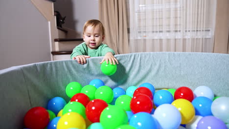 niño pequeño jugando en un pozo de pelota