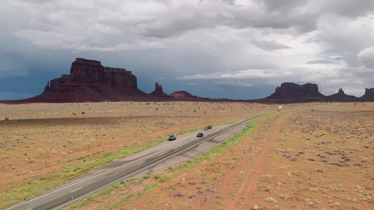 toma de drones de vehículos que pasan por una carretera en medio del desierto.