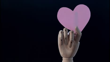 4k stop motion mano ralentizando papel corazón símbolo de amor en el fondo, el concepto del día de san valentín.