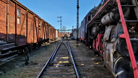 Old-Wooden-Train-Carriage-And-Steam-Locomotive-At-The-Rail-Yard